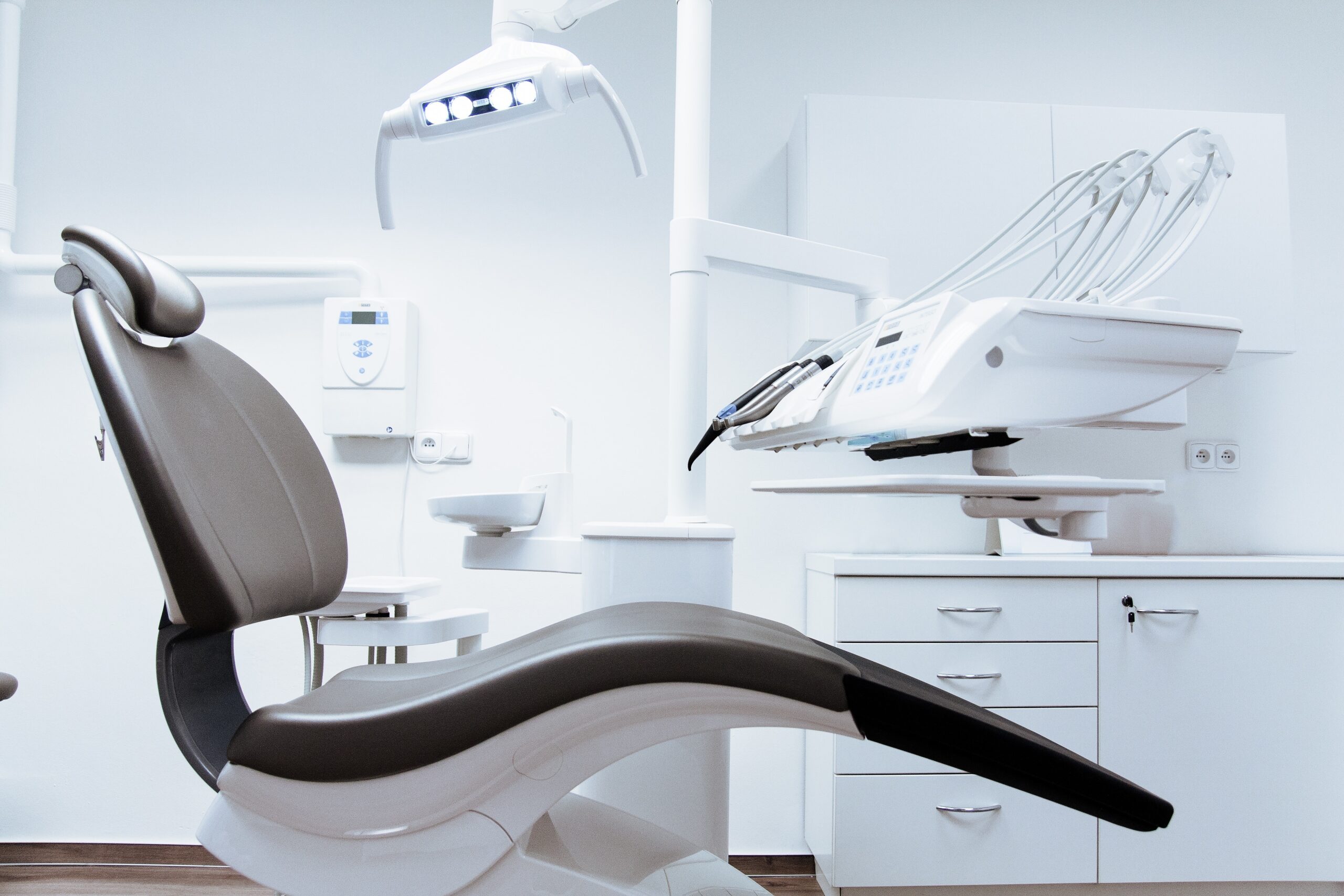 Empty dentist chair in a modern and clean dental office .